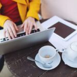 A freelancer working a gig job from a laptop at a cafe.