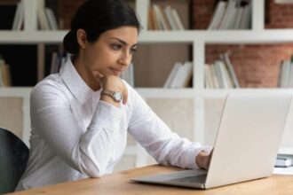 Smart young brown businesswoman working from home on a laptop