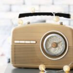 A vintage radio decorated with string lights sitting on a table.