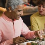 Mature couple in a discussion while eating a meal in a restaurant.