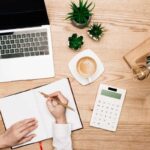 Woman at home, using a calculator to determine budget for unpaid bills