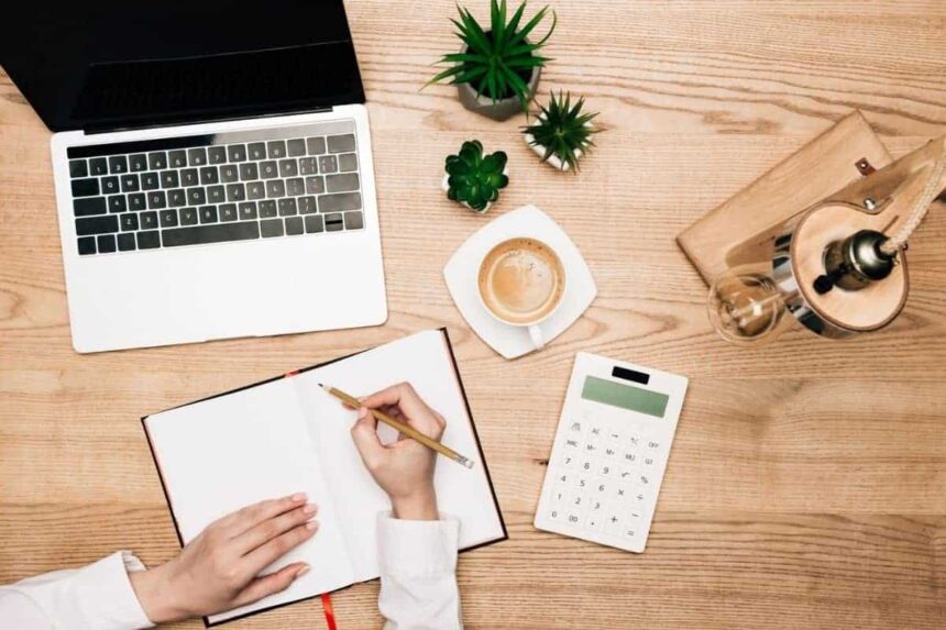 Woman at home, using a calculator to determine budget for unpaid bills