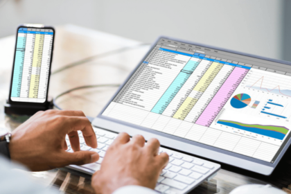 A professional working on a laptop with Awesome Spreadsheet Apps and charts displayed on the screen while also viewing similar data on an iPhone in hand.