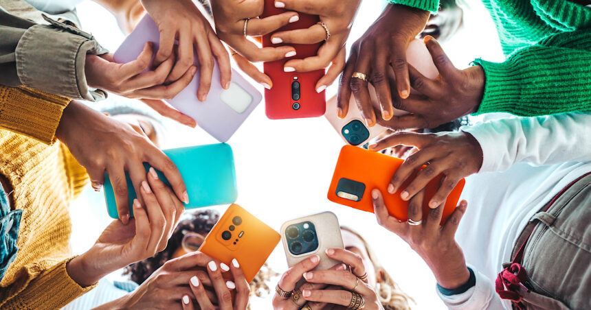 Group of young people using smart mobile phone device outside