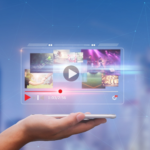 A hand holding a smartphone displaying a video streaming interface with various thumbnail previews, against a blurred cityscape background, at IAB NewFronts 2024.