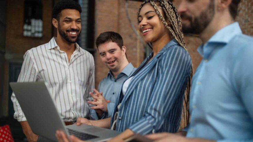 Cheerful young businesspeople with laptop working in office