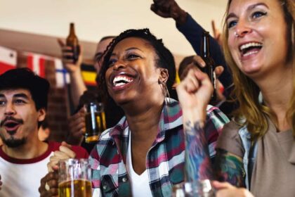 Diverse group of friends cheering sport at bar together