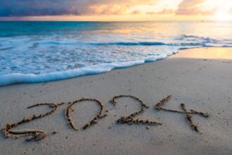 2024 year number handwritten on a sandy beach at sunrise