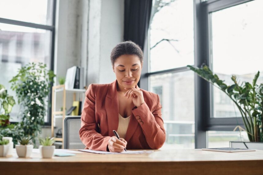 A remote human resources professional working from home office and writing in a notebook.