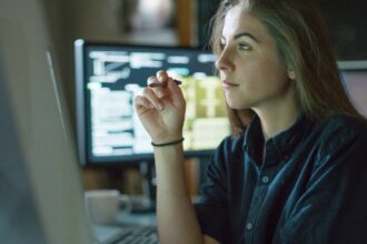 Young female analyst working at her desk in the office