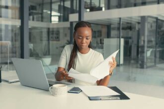 Shot of a young Black woman doing some paperwork in a modern office