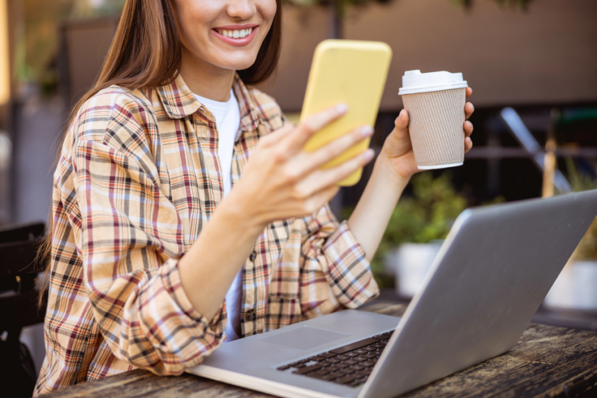 Woman using her smartphone to earn free starbucks gift cards while drinking coffee