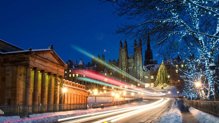 Light trails from traffic moving down The Mound in central Edinburgh, Scotland during December