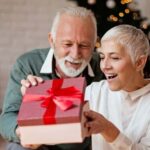 Elderly man giving a Christmas present to his wife