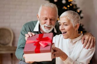 Elderly man giving a Christmas present to his wife