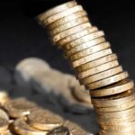 Stack of one pound coins falling over