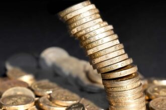 Stack of one pound coins falling over