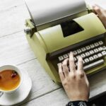 Woman on typewriter with a cup of tea