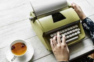 Woman on typewriter with a cup of tea