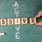 Passive and Active: text from letters of the wooden alphabet on a green chalk board